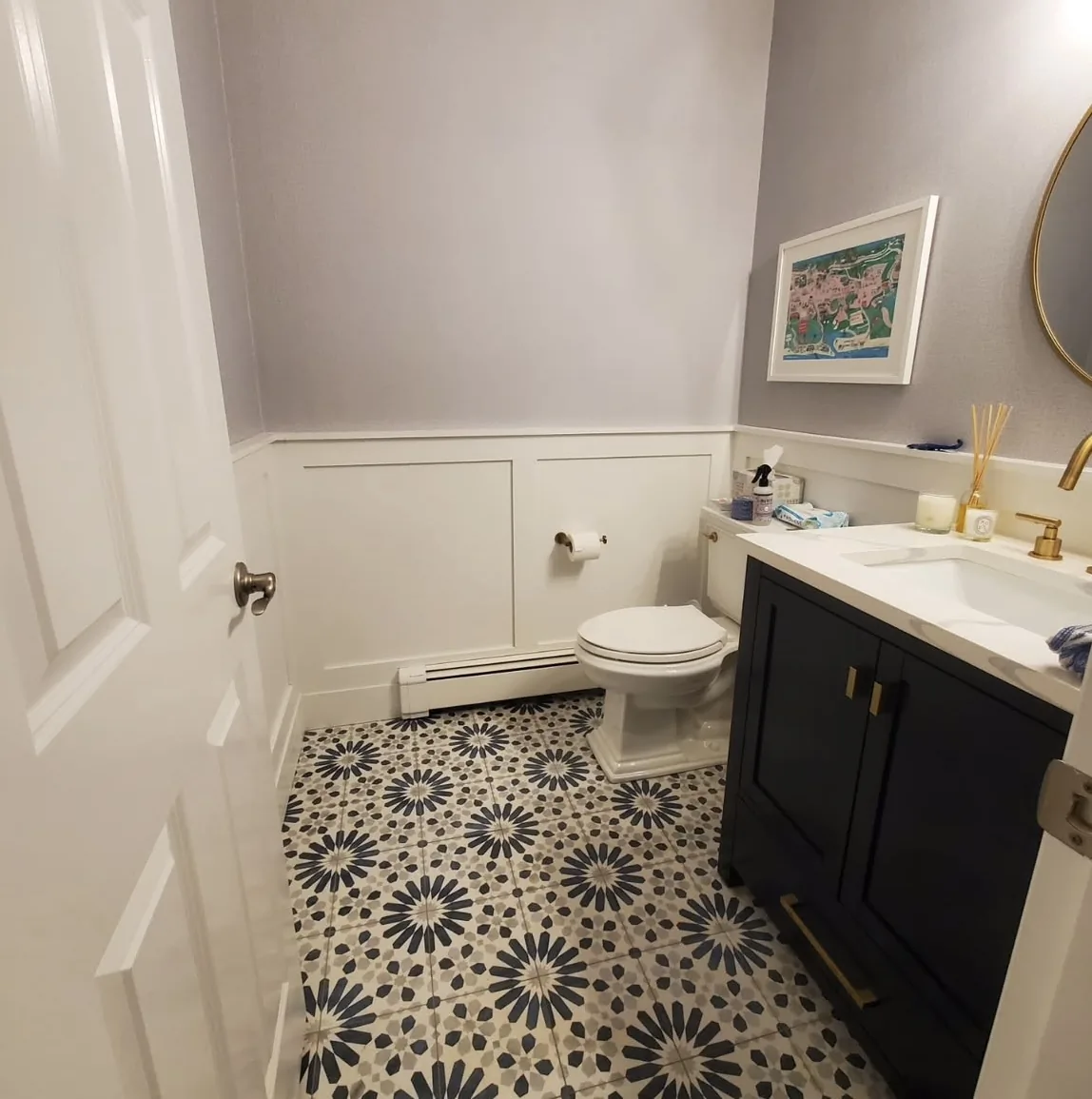 Painted half bathroom with lavender walls and crisp white wainscoting by Bos-Flo Coatings
