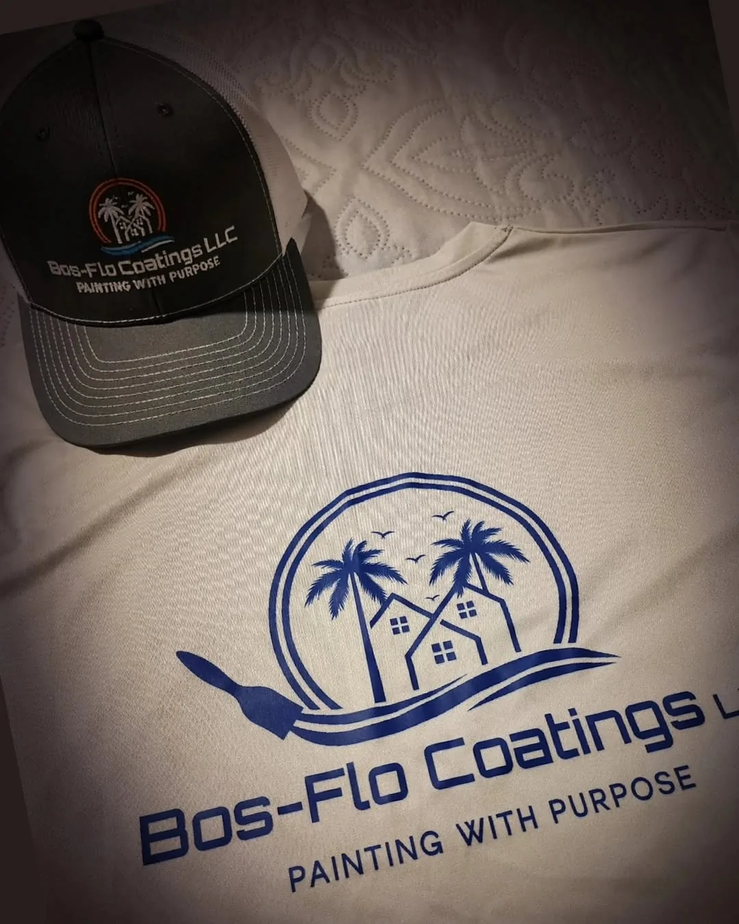 Bos-Flo Coatings logo with palm trees, houses, and slogan on a beige shirt next to a branded black and grey cap